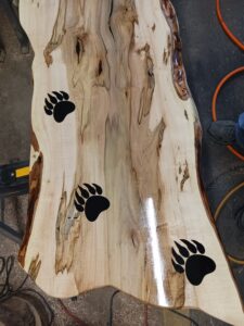carved polished wooden slab with bear prints